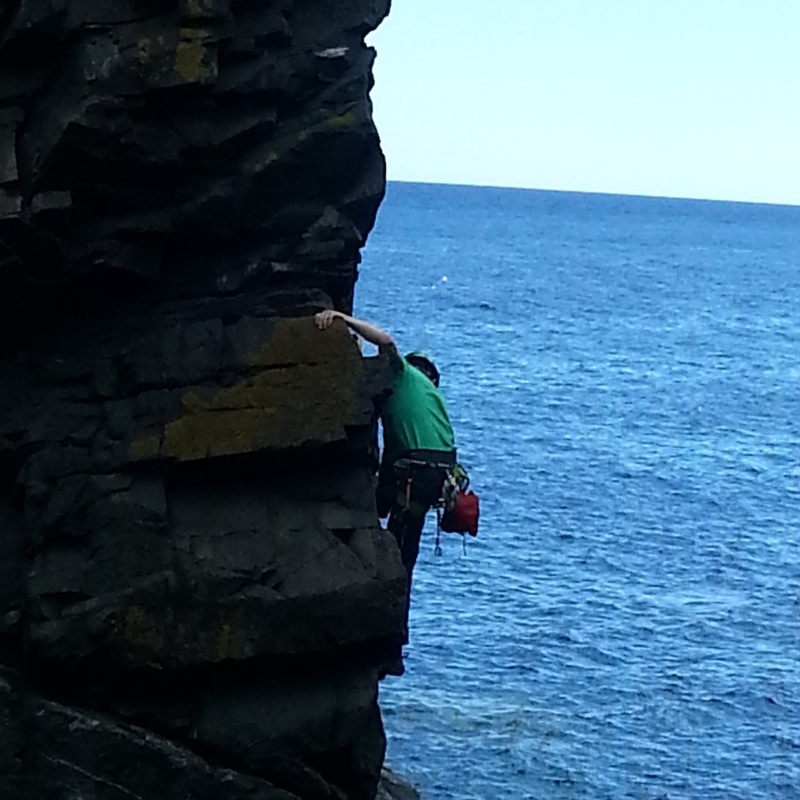 A young Edinburgh climber on the bad step round the arete to the bottom of Ordinary Route
